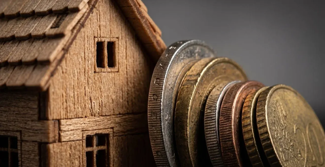 Rappresentazione visiva del rapporto loan-to-value con un modellino di casa e monete