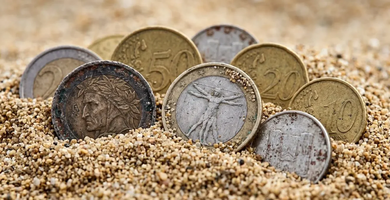 Rappresentazione visiva di monete che perdono valore e si corrodono nel tempo, a simboleggiare l'erosione del debito con l'inflazione.